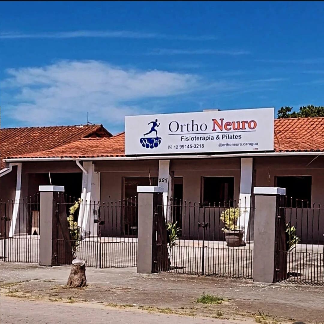 Fachada da clínica Ortho Neuro com a placa na entrada, em Caraguatatuba